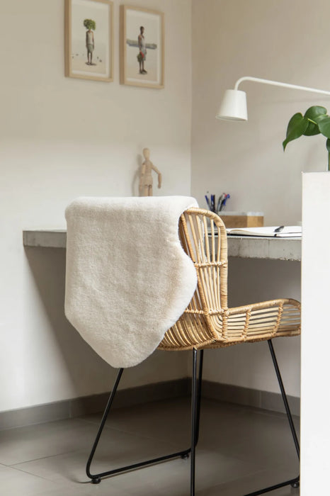 Covor blanita crem pe scaun de birou, pufos si elegant, ideal pentru decor modern
