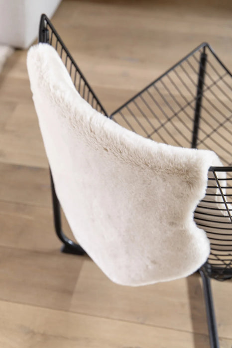 Covor blanita crem folosit pe scaun, pufos si moale, ideal pentru decor cozy si confort