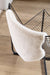 Covor blanita crem folosit pe scaun, pufos si moale, ideal pentru decor cozy si confort