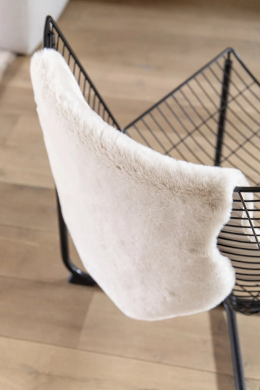 Covor blanita crem folosit pe scaun, pufos si moale, ideal pentru decor cozy si confort