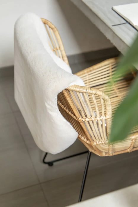 Covor blanita crem pe scaun de relaxare, moale si confortabil, ideal pentru spatii cozy