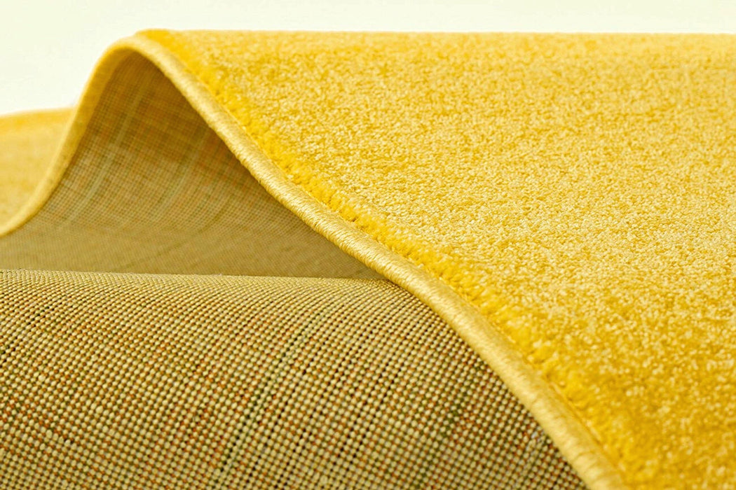 Covor galben rotund cu textura moale si finisaj premium pentru interior modern