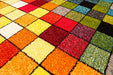 Detaliu model geometric multicolor pe un covor living modern cu aspect elegant.