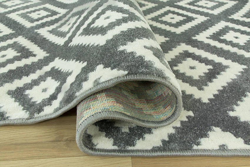 Detaliu al covorului living geometric cu textura placuta si material rezistent la utilizare zilnica.
