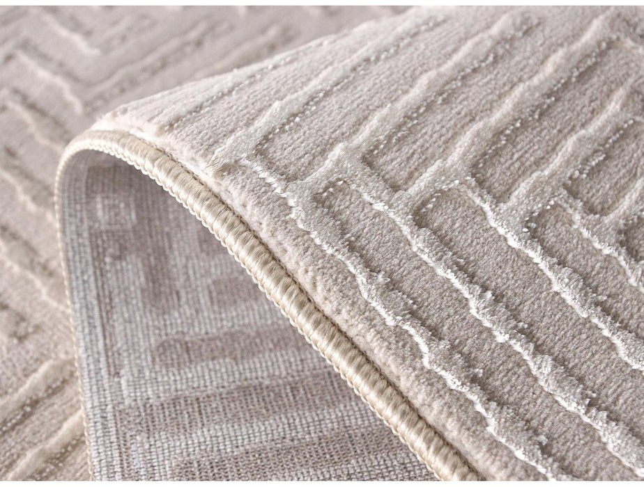 Detaliu model geometric texturat pe covor crem modern, fibre moi si confortabile