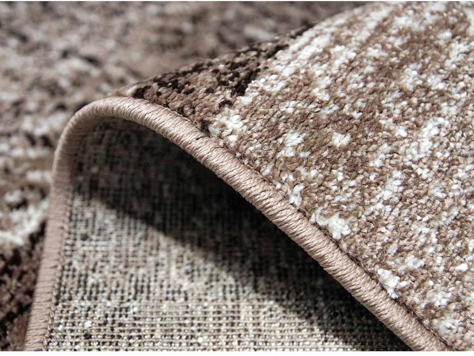 Detaliu margine covor maro cu finisaj festonat si cusaturi rezistente, calitate premium