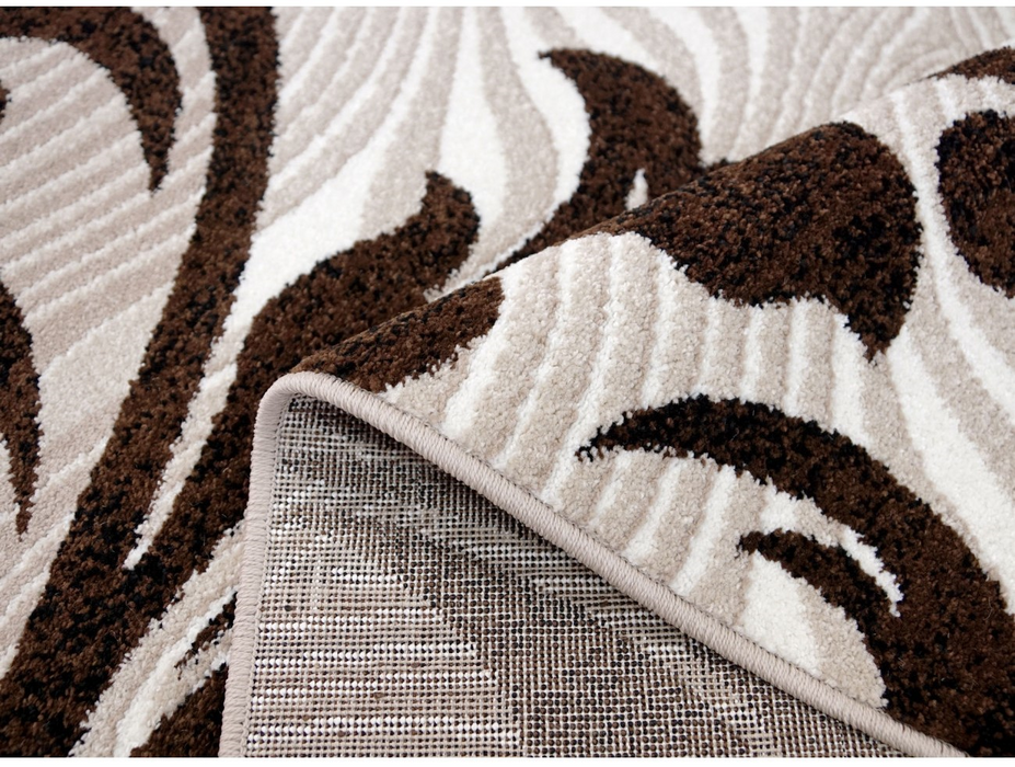 Detaliu textura covor oval modern cu model maro reliefat si fir moale