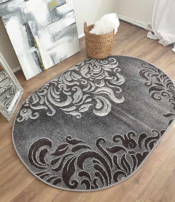 Covor oval modern gri prezentat din unghi lateral evidentiind textura moale si forma rotunjita