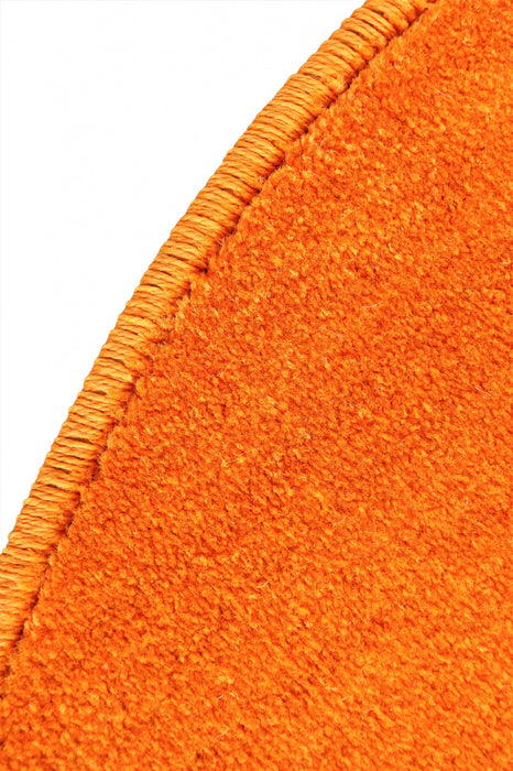 Detaliu covor portocaliu rotund cu textura premium si finisaj de calitate pentru interior modern