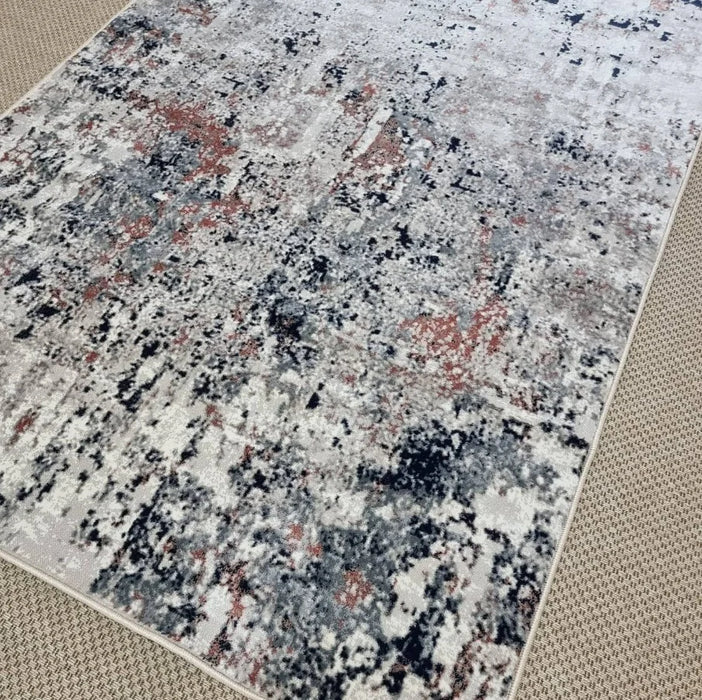 Detaliu model abstract cu nuante bej gri si accente caramizii pe covor modern