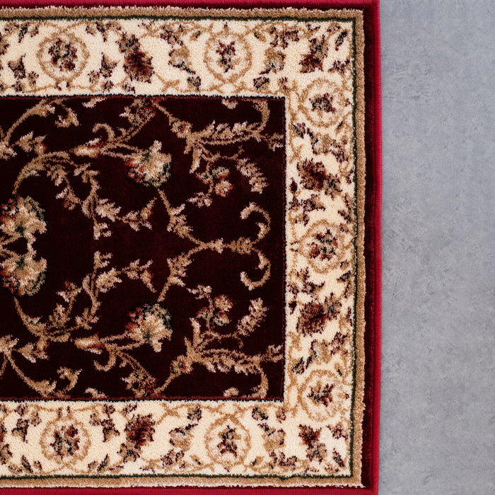 Detaliu model floral și bordură decorativă pe covor clasic grena