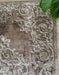 Detaliu model ornamental damask pe covor clasic maro