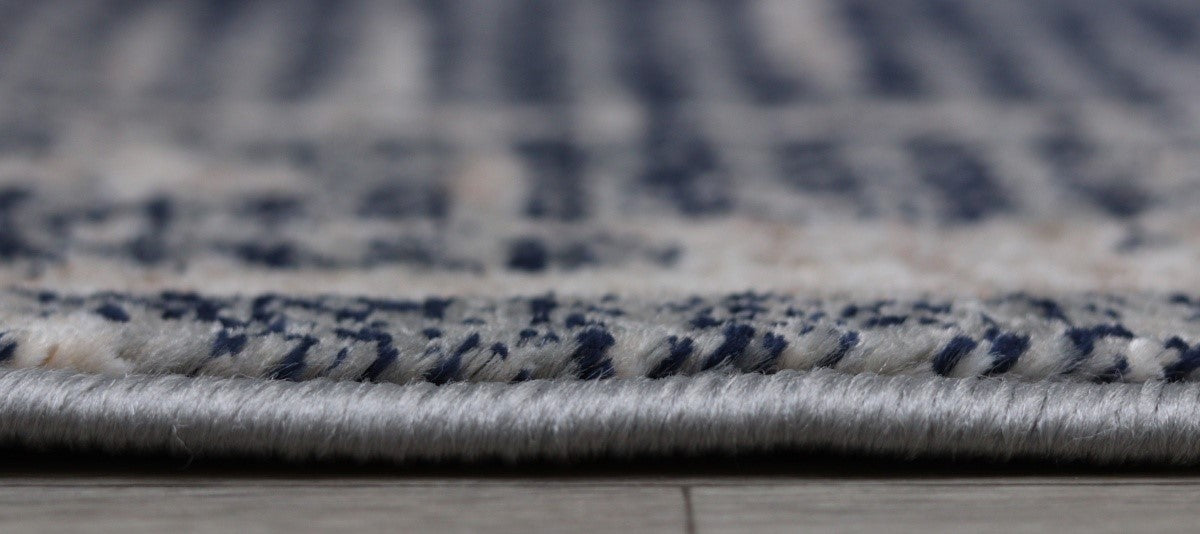 Detaliu margine festonata traversa covor gri moderna cu textura densa si finisaj atent