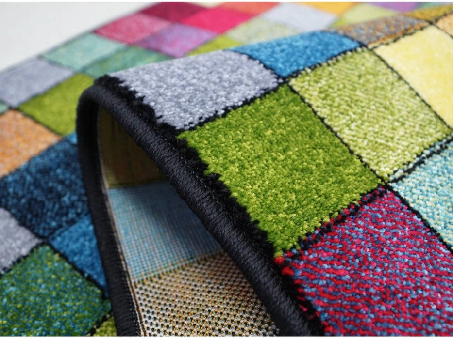 Detaliu grosime si finisaj al unui covor premium multicolor cu textura placuta la atingere.