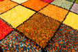 Detaliu model cu patrate colorate pe covor modern pentru living, cu aspect vibrant si decorativ.